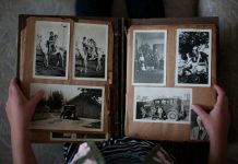 person opening photo album displaying grayscale photos