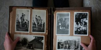 person opening photo album displaying grayscale photos