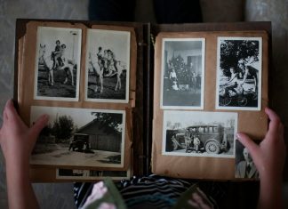 person opening photo album displaying grayscale photos