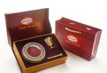 a red box with a gold plate and a golden spoon in it