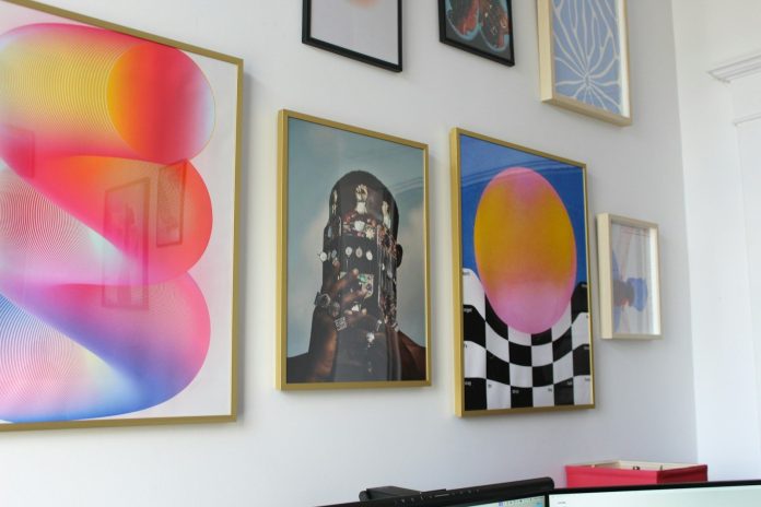 Photo by Serena Tyrrell a wall with a bunch of paintings on it