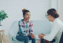 The Hidden Cost of Skipping Mental Health Days at Work Two women talking in a modern office setting