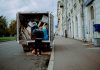 a man unloading furniture from the back of a moving truck