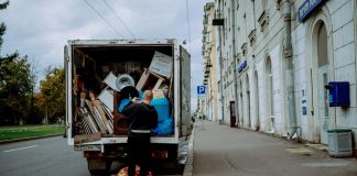 a man unloading furniture from the back of a moving truck