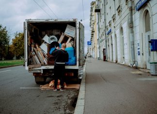 a man unloading furniture from the back of a moving truck