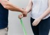 a man and a woman holding a green stick