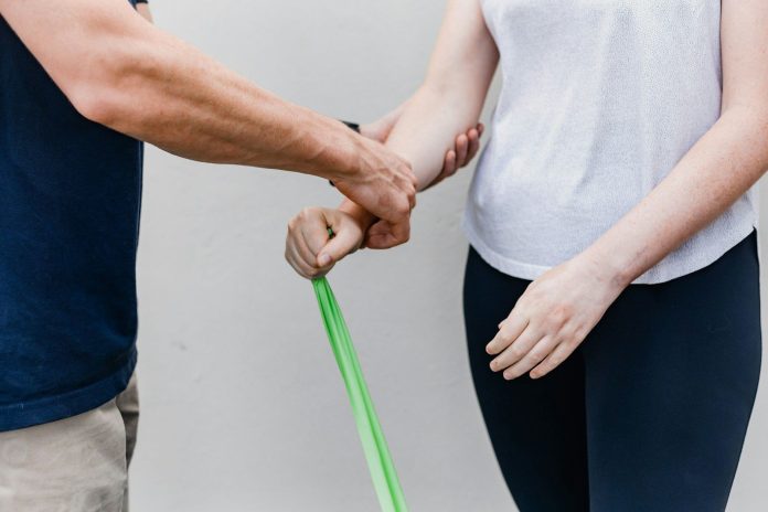 Photo by Sincerely Media a man and a woman holding a green stick
