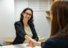 How to Change Careers Without Wasting the Education You Already Have a woman shaking hands with another woman sitting at a table