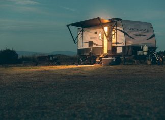 a small camper sits in a field at night