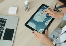 Doctor examining brain scan on tablet at desk